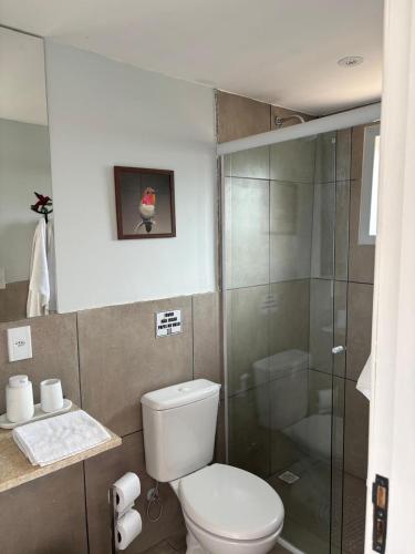 a bathroom with a toilet and a glass shower at Suites da Dani in Areal