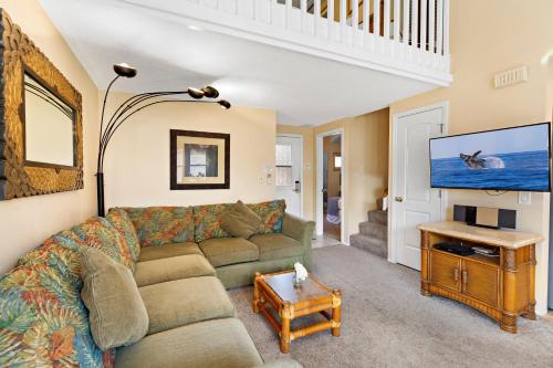 a living room with a couch and a tv at Kihei Sands B2 in Kihei