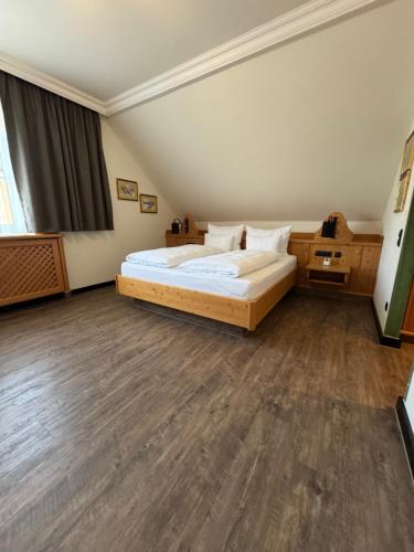 Un dormitorio con una cama grande y suelos de madera. en Self-Check-in Hotel VinoQ Mistelbach, en Mistelbach