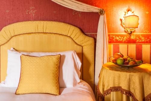 a bedroom with a bed with a bowl of fruit on a table at Castello Di Spessa - Residenze d'epoca in Capriva del Friuli