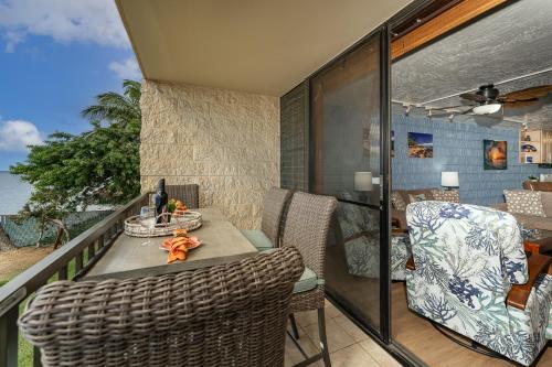 a balcony with a table and chairs and the ocean at Kanai A Nalu 202 in Wailuku