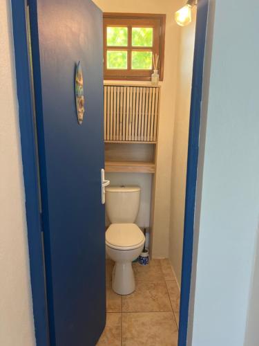 a bathroom with a toilet and a window at Vi la dous Kreyol in Sainte-Rose