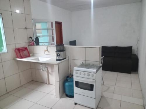 een kleine keuken met een fornuis en een spoelbak bij Casa independente e aconchegante in Poços de Caldas