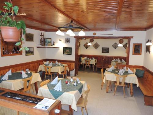 comedor con mesas y sillas y techos de madera en Gasthof Staud'nwirt en Bad Aussee