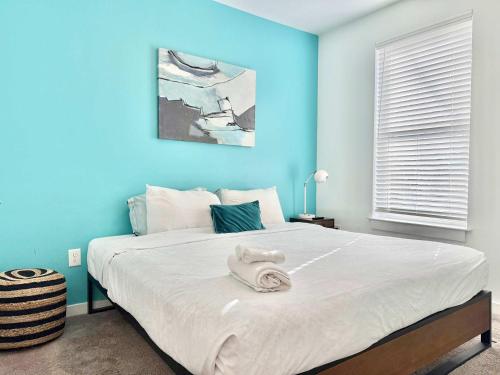 a blue bedroom with a large bed with a towel on it at Brand-new Parkview with Balcony in Old Fourth Ward 542Blvd in Atlanta
