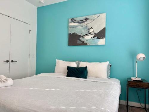 a blue bedroom with a bed with a blue wall at Brand-new Parkview with Balcony in Old Fourth Ward 542Blvd in Atlanta
