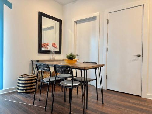 a dining room with a table and chairs and a mirror at Brand-new Parkview with Balcony in Old Fourth Ward 542Blvd in Atlanta