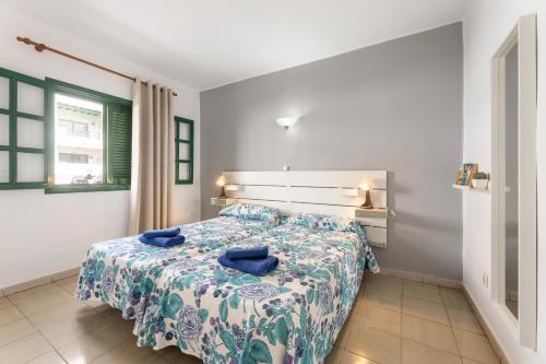 une chambre avec un lit avec des oreillers bleus dessus dans l'établissement Apartamentos Luz Y Mar, à Puerto del Carmen