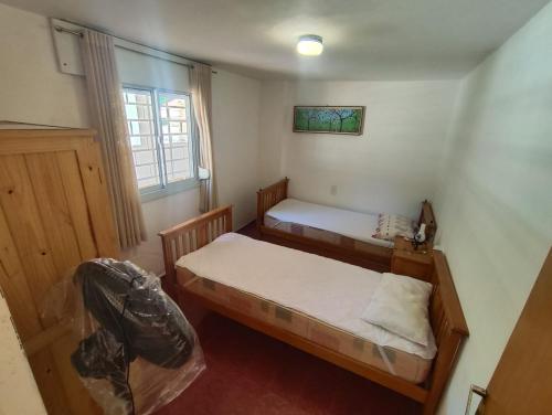 a bedroom with two beds and a window at Rincón del Rio San Antonio in San Antonio de Arredondo