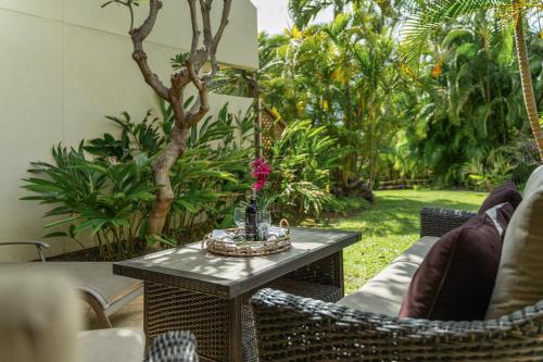 a patio with a table and chairs and trees at Maui Kamaole K104 in Wailea