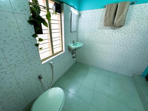 a bathroom with a toilet and a sink at Massbungalow in Tindummal
