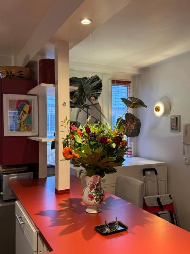 Red Flat Paris في باريس: مطبخ مع طاولة عليها مزهرية من الزهور