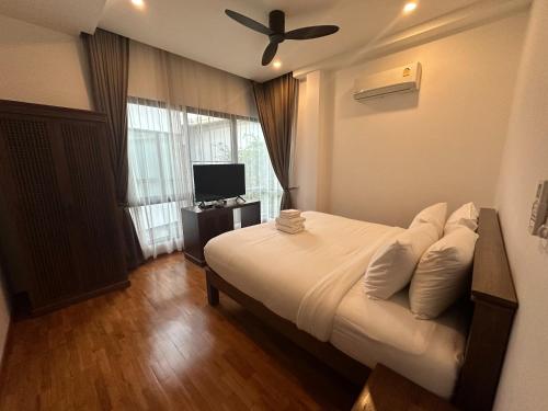 une chambre avec un lit et un ventilateur de plafond dans l'établissement Chic Villa 6, à Chiang Mai