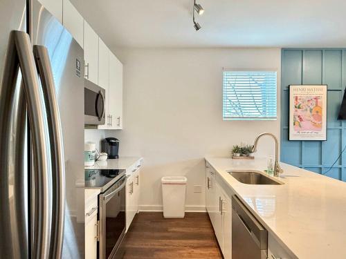 a white kitchen with a sink and a refrigerator at New Downtown ATL Condo Washer Dryer 542Blvd107 in Atlanta