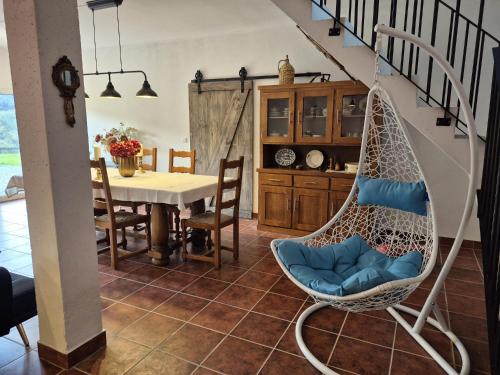 a swinging chair in a dining room with a table at Casa Belavista no Geres by In'Canto Property Management in Ponte da Barca