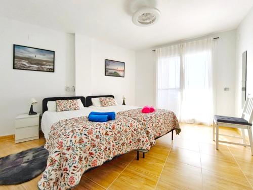 a bedroom with a bed with blue pillows on it at Apartamento con piscina en el Delta del Ebro in Sant Jaume d'Enveja