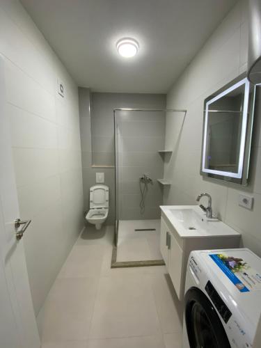 ein Badezimmer mit Dusche, Waschbecken und Toilette in der Unterkunft L Apartaments in Peja
