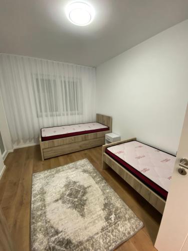 ein Zimmer mit zwei Betten und einem Teppich in der Unterkunft L Apartaments in Peja