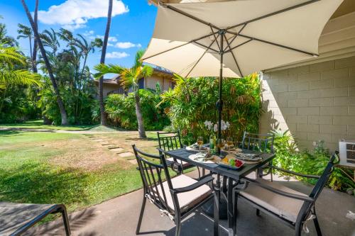 a table and chairs with an umbrella on a patio at Maui Sands 1B in Honokowai