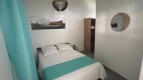 Zen and cozy escape between sea, mountain and river في بوانت-نوار: غرفة نوم بسرير وبطانية خضراء وبيضاء