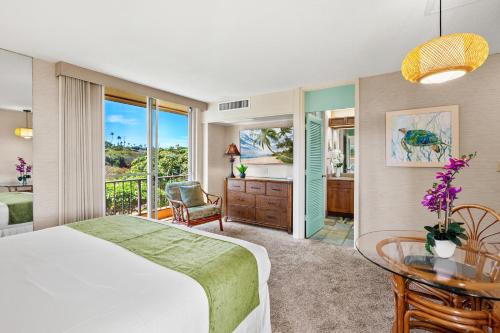 a bedroom with a bed and a desk and a table at Maui Kaanapali Villas A414 in Kaanapali