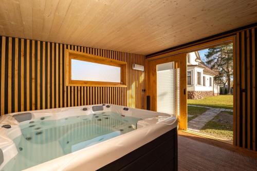 bañera grande en una habitación con ventana en Villa Garden Apartments, en Poprad