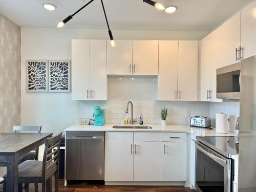 a kitchen with white cabinets and a wooden table at Luxury New Penthouse Roof Balcony Washer Dryer B406 in Atlanta