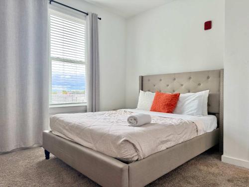 a bedroom with a bed with orange pillows and a window at Luxury New Penthouse Roof Balcony Washer Dryer B406 in Atlanta