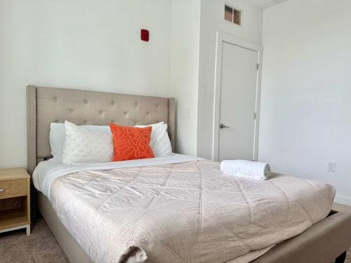 a bedroom with a large bed with an orange pillow at Luxury New Penthouse Roof Balcony Washer Dryer B406 in Atlanta