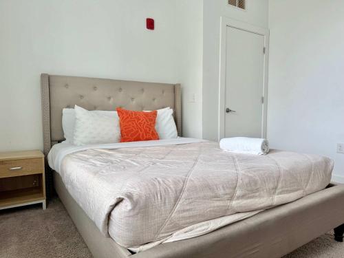 a bedroom with a large bed with an orange pillow at Luxury New Penthouse Roof Balcony Washer Dryer B406 in Atlanta