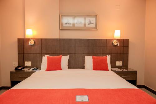a bedroom with a large bed with red pillows at Howard Johnson Ciudad del Este in Ciudad del Este