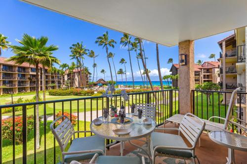 a balcony with a table and chairs and the ocean at Papakea C209 in Honokowai