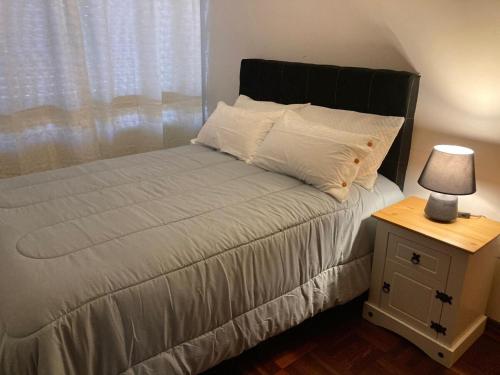 a bedroom with a bed with a lamp on a night stand at Apartamento en pleno centro in Salto