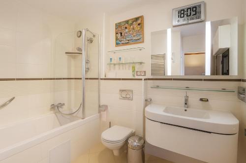a white bathroom with a sink and a toilet at Appartement Premium 100 m2 avec Jardin Privé Plage et Centre à 400 m in Deauville