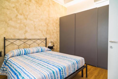 een slaapkamer met een bed met een gestreept dekbed bij P&P House 38 Bilo 2 in Bergamo
