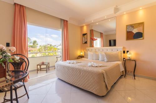 a bedroom with a bed and a large window at Villa Araçà - Boutique Hotel in Lauro de Freitas