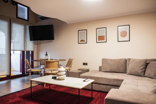 Tollmere Hospitality Λύχνος suite في ليفاديا: غرفة معيشة مع أريكة وطاولة