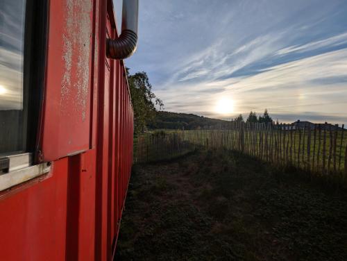 a red train looking out of a window at a vineyard at Auszeit im Bauwagen in Arnsdorf