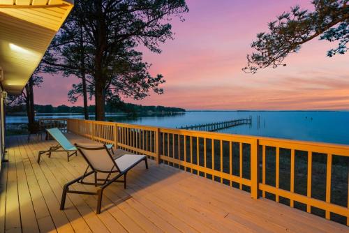 a deck with chairs and a view of the water at Adventures on the Bay - Bayfront Escape, Private Dock, Large Deck, and Lake Views! in Hudgins