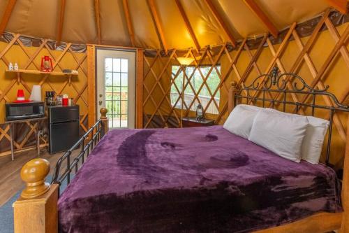 een slaapkamer met een bed in een yurt bij Summerset Ridge - 100 Acre Reserve, River Access, and Endless Adventure! in Cullowhee