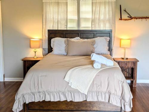 a bedroom with a large bed with two lamps at Redwing Farm Cottage - Mountain Views and Firepit! in Bedford