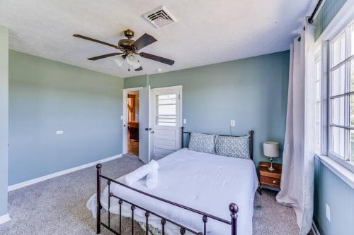 een slaapkamer met een bed en een plafondventilator bij Redwing Farm Cottage - Mountain Views and Firepit! in Goode