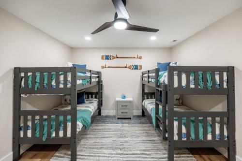 een slaapkamer met 2 stapelbedden en een plafondventilator bij Bass Cove - Luxury Lakefront, Hot Tub, Fire Table & Theatre! in Kasey