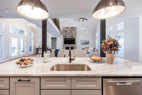 een keuken met een spoelbak en een woonkamer bij Bass Cove - Luxury Lakefront, Hot Tub, Fire Table & Theatre! in Kasey