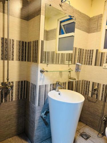 a bathroom with a white sink and a shower at Syed Apartment 104 in Islamabad