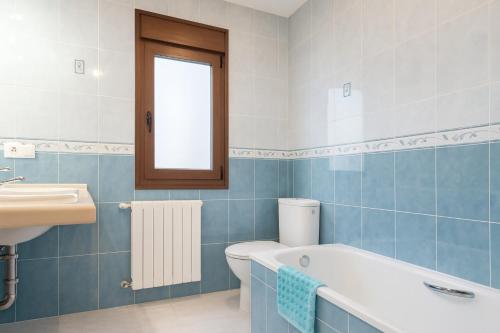 un bagno con vasca, WC e lavandino di Casa vacacional La Vicoca a Poo de Llanes