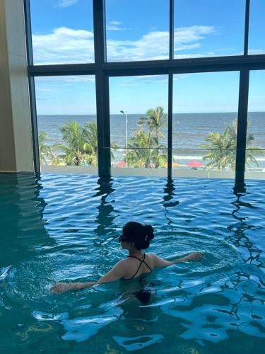 Flamingos Hải Tiến -view biển في Gò Ba Quần: امرأة في حمام السباحة تطل على المحيط