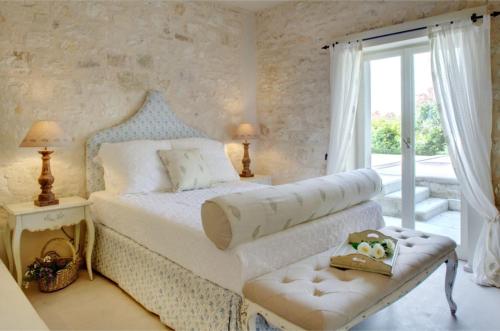 a bedroom with a white bed with a window at Kallista House in Kourtaíïka