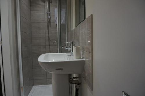 a bathroom with a sink and a shower at Town Centre Apartments in Dewsbury