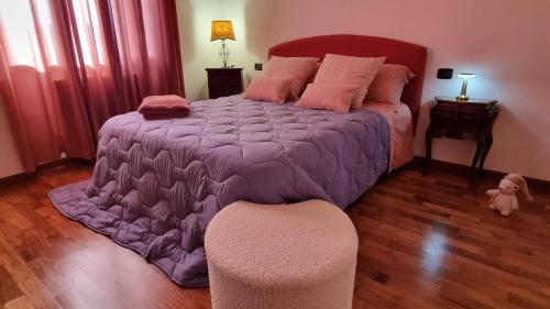 a bedroom with a large bed with a purple comforter at Assisi - Appartamento Maristella in Santa Maria degli Angeli